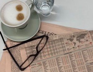 Börsebericht Die Zeitung Der Standard mit einer Lesebrille und einer Tasse Cappuchino